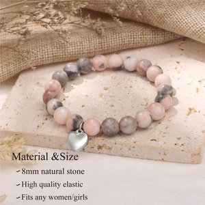 Détail d'un bracelet en pierres naturelles 8mm rose et gris avec un pendentif cœur