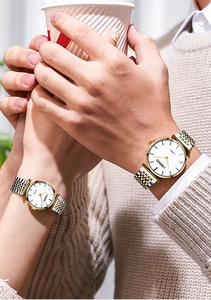 Close-up of elegant couple quartz watches with silver and gold stainless steel bands