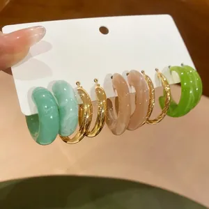 Lot de 5 boucles d'oreilles créoles C en acrylique et dorées sur carte présentoir