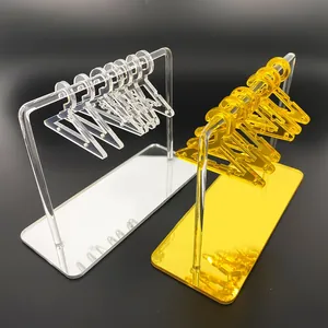 Detailed view of clear and gold acrylic hanger earring stands on a black surface
