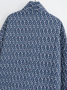 Detailed close-up of quilted diamond pattern and stitching on navy blue winter jacket