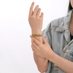 Close-up of golden stainless steel mesh chain bracelet worn on wrist for fashion detail