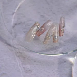 Detail of jelly press-on nails featuring 3D silver butterflies and pearls on gradient pink