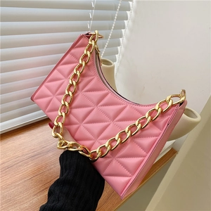 Detailed view of pink quilted underarm bag featuring a chunky gold chain strap