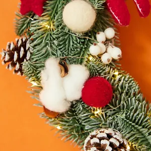 Christmas moon wreath with LED lights, pine cones, cotton and berries on spruce needles