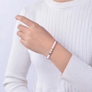Detail of adjustable Bohemian beaded bracelet with white crystals on female wrist