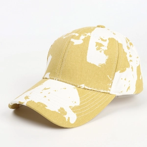 Détail d'une casquette en coton tie-dye avec motifs abstraits jaunes et blancs