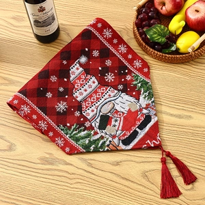 Detail of red plaid Christmas gnome table runner with white snowflakes and red tassels