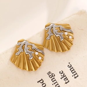 Macro shot of seashell earrings with gold and silver accents and small pearls
