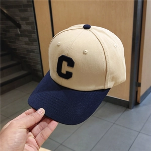 Close-up of two-tone baseball cap with large C letter patch and cotton canvas texture