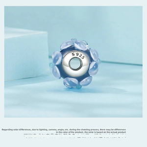 Detailed close-up of S925 sterling silver charm with blue translucent glass flower petals