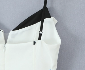 Détail des fines bretelles et du patchwork noir et blanc sur une robe à pois