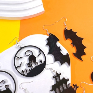 Macro detail of acrylic Halloween earrings featuring black cat and bat cutout silhouettes