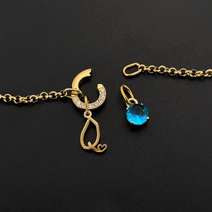 Detail of gold stainless steel alphabet Q charm and blue gemstone necklace pendants