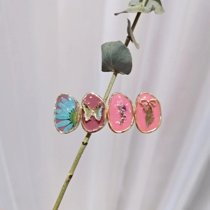 Detail of Morandi-toned floral hair clips with blue flowers and butterflies on a stem