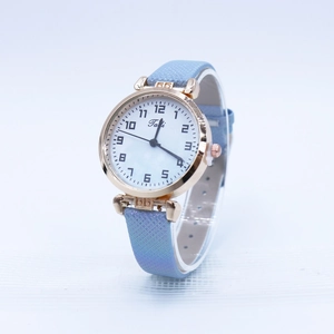Women's quartz watch with gradient blue strap and rose gold numeral dial on a stand