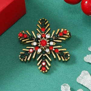 Christmas snowflake brooch with multicolor crystals on a gold festive background