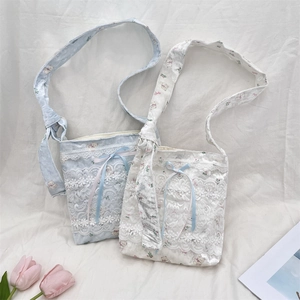 Two cute lace shoulder bags with bear patterns and ribbon bows on white fabric background