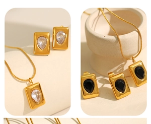 Detail of 18K gold plated jewelry set featuring emerald green and clear drop stones