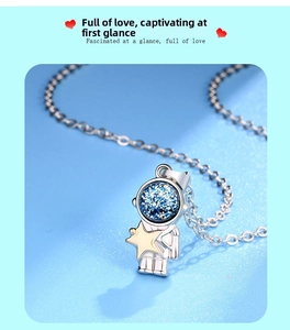 Macro detail of astronaut pendant with blue glitter helmet and gold star on O-chain