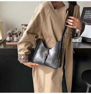 Détail du sac seau rétro gris foncé avec passepoil blanc et boucle argentée chic
