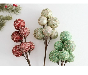 Close-up of glittery Christmas berry stems in red and gold for festive table decoration