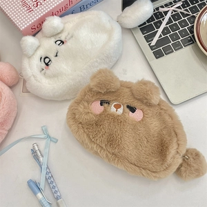 Détail macro de trousses animaux en peluche avec oreilles duveteuses et zip à pompon