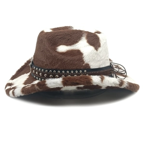 Detail van pluche cowboyhoed met koeienprint, versierde leren band en verstelbare kinriem