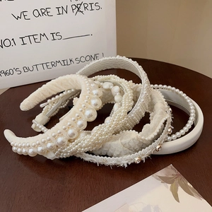 Close-up of pearl headbands with textured fabric and elegant retro designs