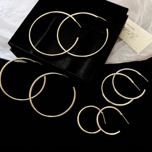 Set of 4 minimalist silver geometric C-shaped hoop earrings in various sizes on black background