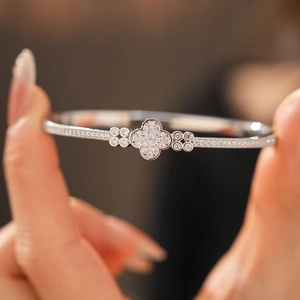 Detailed close-up of a silver four-leaf clover bangle encrusted with zircon stones