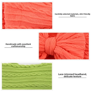 Detail of cable knit nylon baby headbands with oversized bows in coral and teal colors
