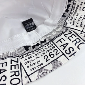 Detail of 100% cotton newspaper print bucket hat with brand logo label and stitching