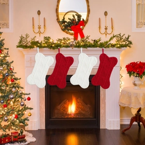 Juego de cuatro calcetines de Navidad de punto en forma de hueso en una chimenea decorada