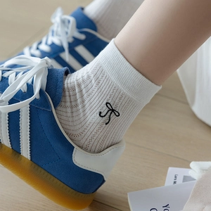 White ribbed crew socks with black bow jacquard pattern in ballet core style