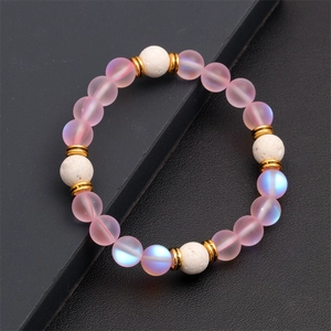 Dettaglio delle perle occhio di gatto rosa e pietre vulcaniche bianche del bracciale