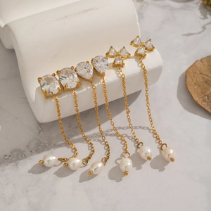 Detailed view of long gold tassel earrings with zircon studs and natural freshwater pearls