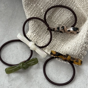 Set of four minimalist acetate bow hair ties in leopard, green, white, and tortoiseshell