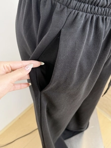 Detail of high waist elastic waistband and deep side pockets on black wide leg sweatpants