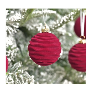 Detail of 6cm burgundy velvet Christmas ball with wave texture on a frosted tree branch