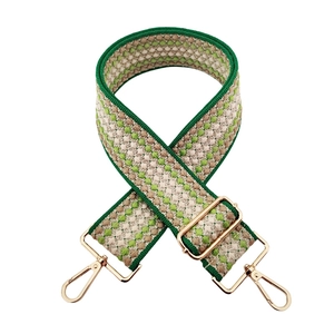 Macro shot of green and beige diamond woven shoulder strap with gold metal buckle hardware