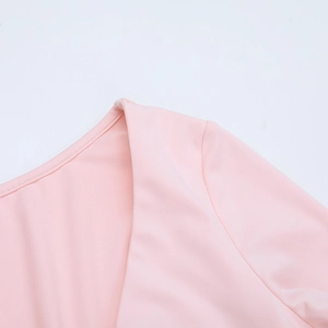 Détail du décolleté en V profond et de l'épaule à volants sur cette robe rose