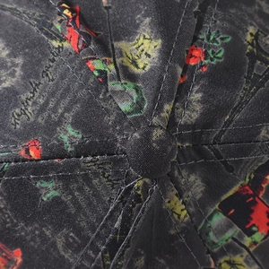 Detailed close-up of dark grey twill baseball cap with Eiffel Tower floral print and top button