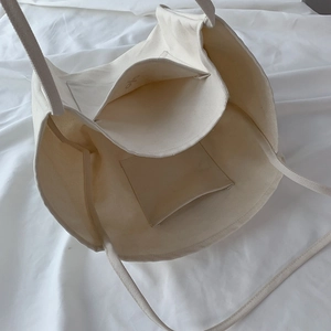 Detail of canvas tote bag interior with reinforced stitching and multi-pocket storage