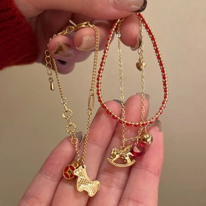 Gold plated horse bracelet with red weaving and zirconia stones on a minimalist chain