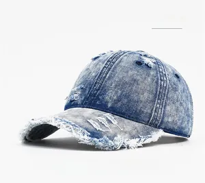 Detail of distressed dark blue denim baseball cap showing frayed edges and ripped holes