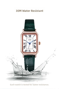 Detail of square quartz watch with green leather strap showing splash water resistance
