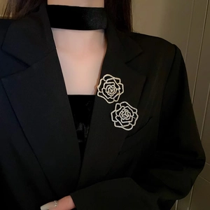 Detailed view of a silver floral brooch with crystals on a black blazer lapel