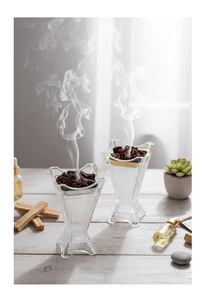 Dettaglio del bruciatore per aromaterapia in vetro con fumo e luce naturale calda
