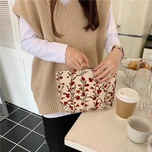 Détail d'une trousse à maquillage vintage en velours côtelé à fleurs avec fermeture